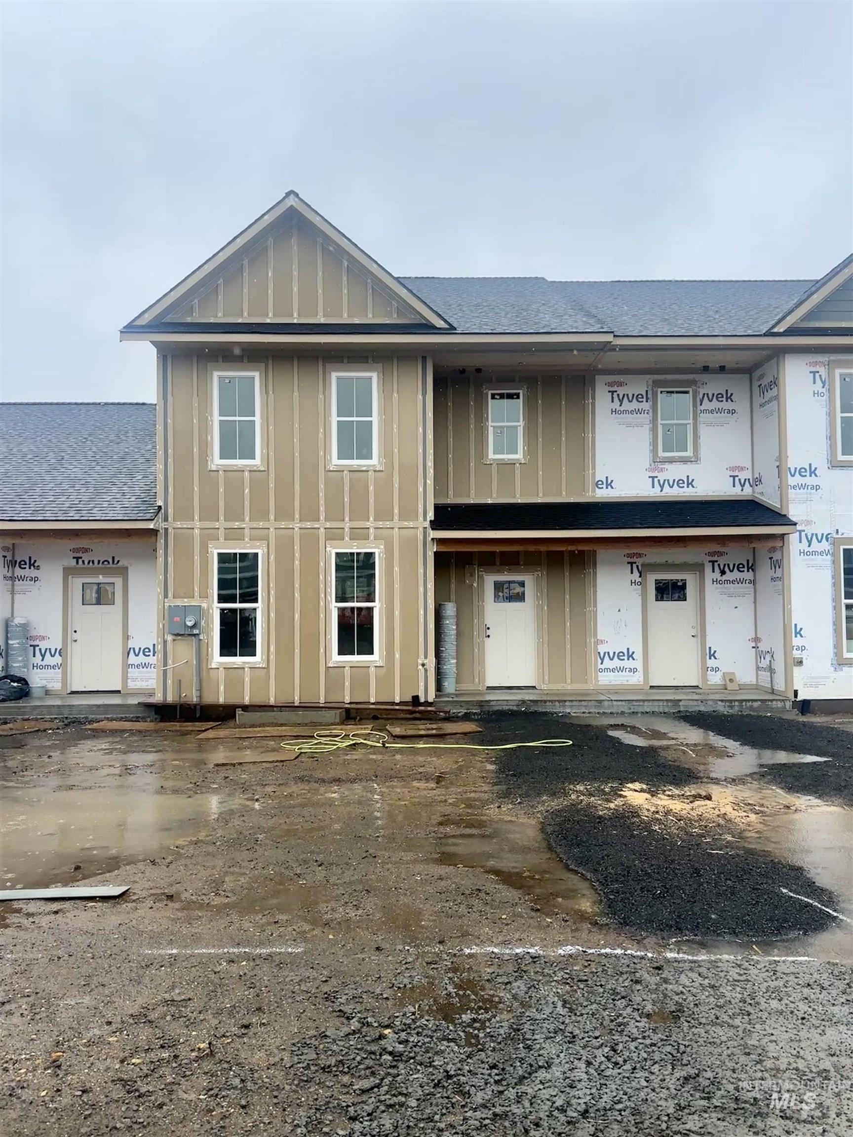 Property under construction with roof with shingles and board and batten siding