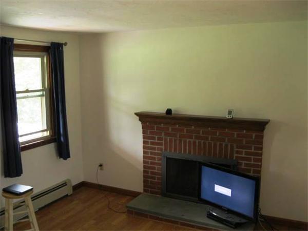 401 Mulpus Road Lunenburg, MA 01462 - Photo 8 of 15 a living room with a fireplace and a table