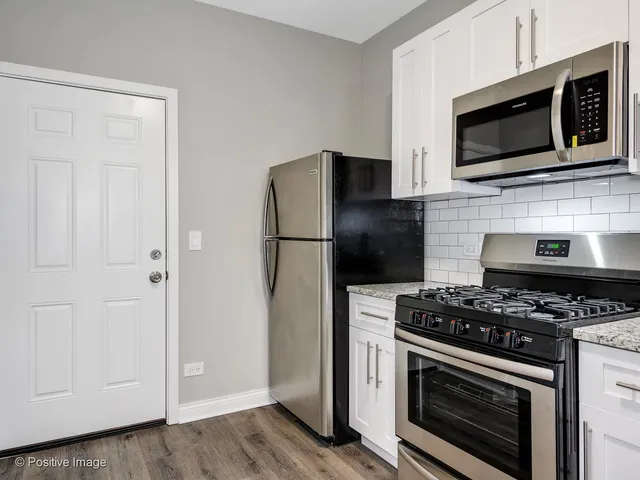 a kitchen with stainless steel appliances a stove a microwave and cabinets