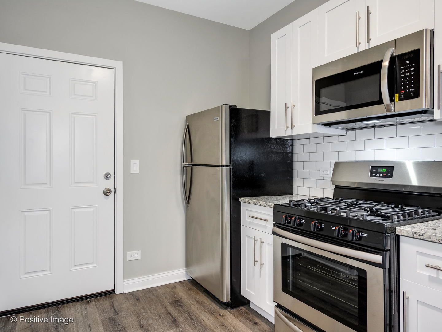 2919 North Kilpatrick Avenue, Unit 2 Chicago, IL 60641 - Photo 3 of 17 a kitchen with stainless steel appliances a stove a microwave and cabinets