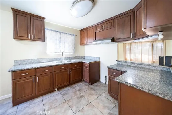 a kitchen with granite countertop a sink stove and cabinets