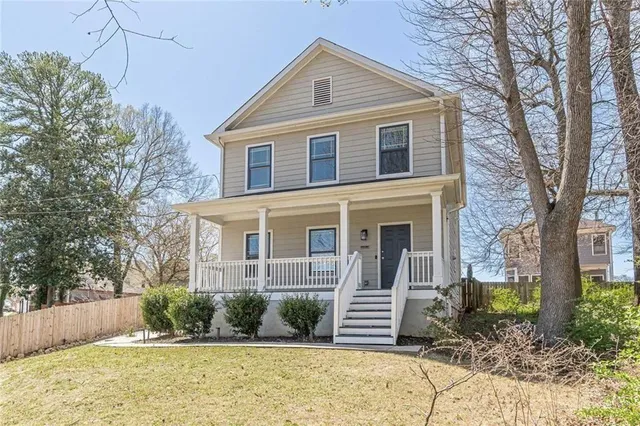 a front view of a house with a yard and potted plants