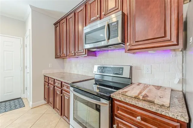 an empty room with chandelier fan and windows