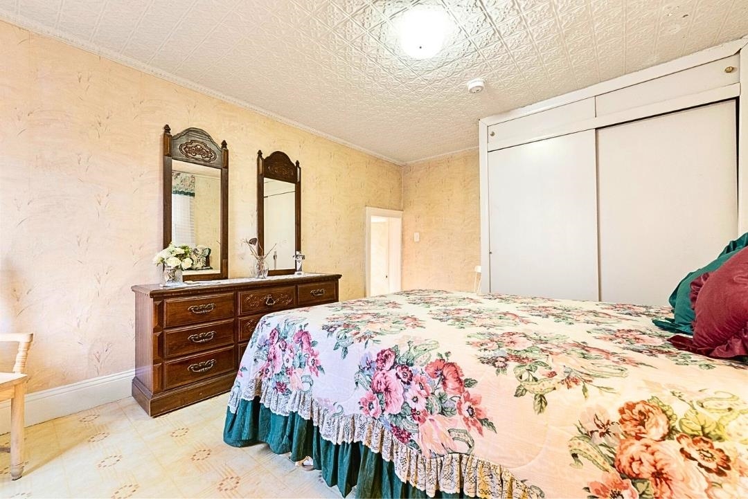 520 27th Street Union City, NJ 07087 - Photo 14 of 19 a bedroom with a bed and dresser with mirror