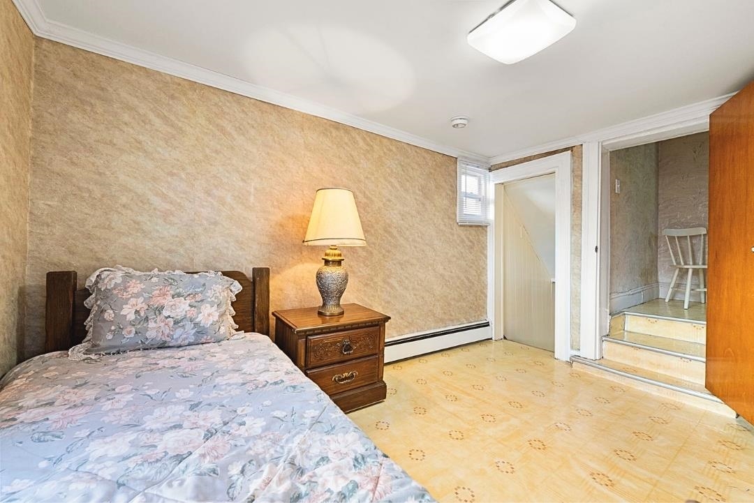 520 27th Street Union City, NJ 07087 - Photo 15 of 19 a bedroom with a bed and a lamp on table