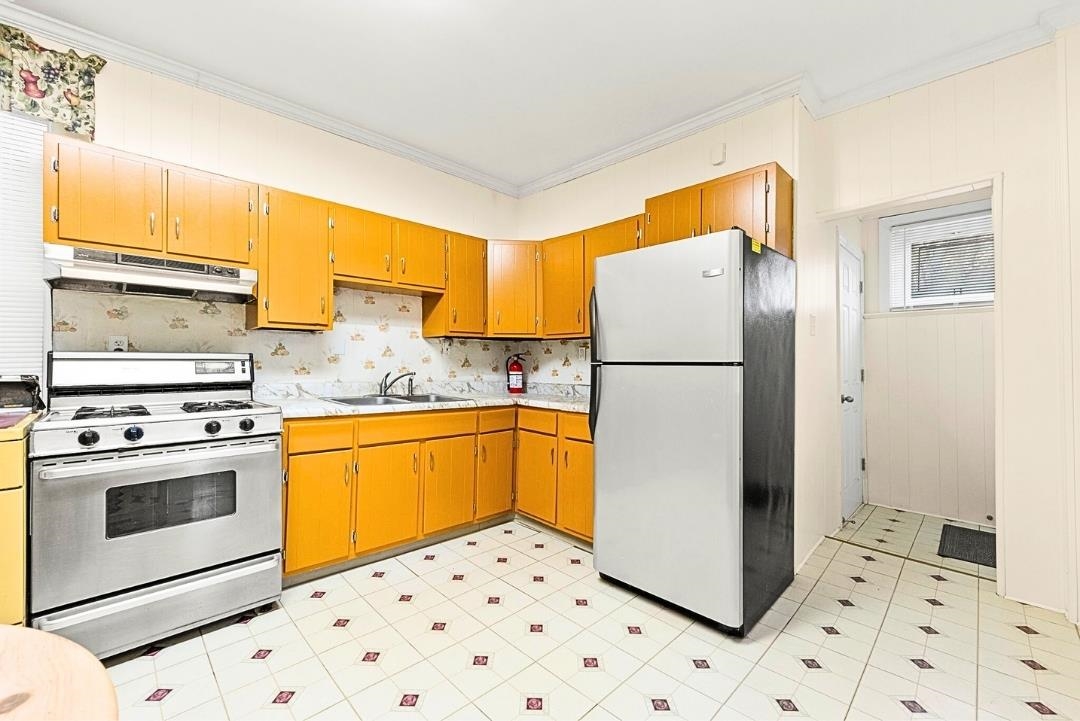 520 27th Street Union City, NJ 07087 - Photo 9 of 19 a kitchen with a refrigerator sink and wooden cabinets