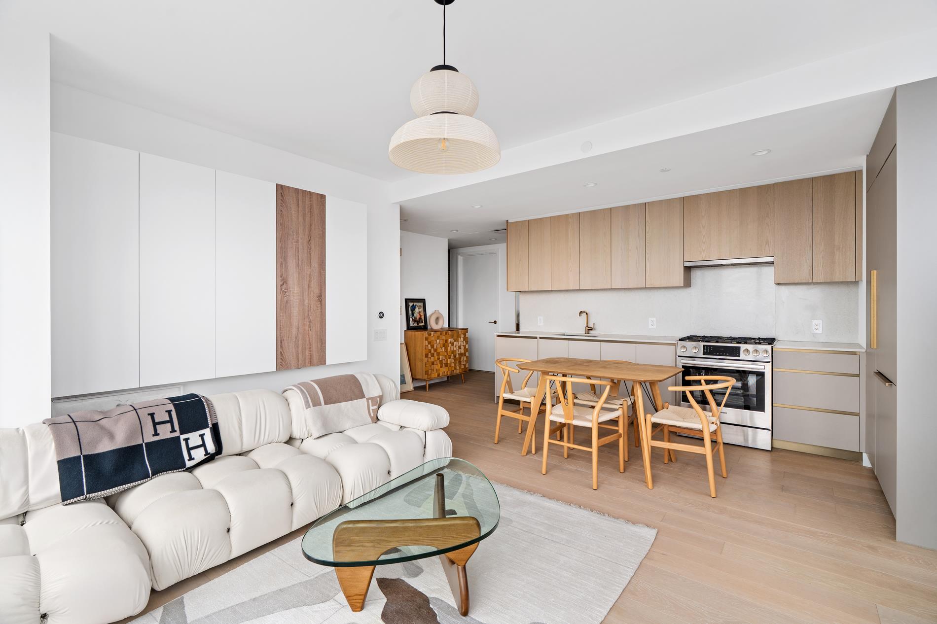 3 Court Square, Unit 2902 Queens, NY 11101 - Photo 2 of 12 a living room with furniture a dining table and kitchen view