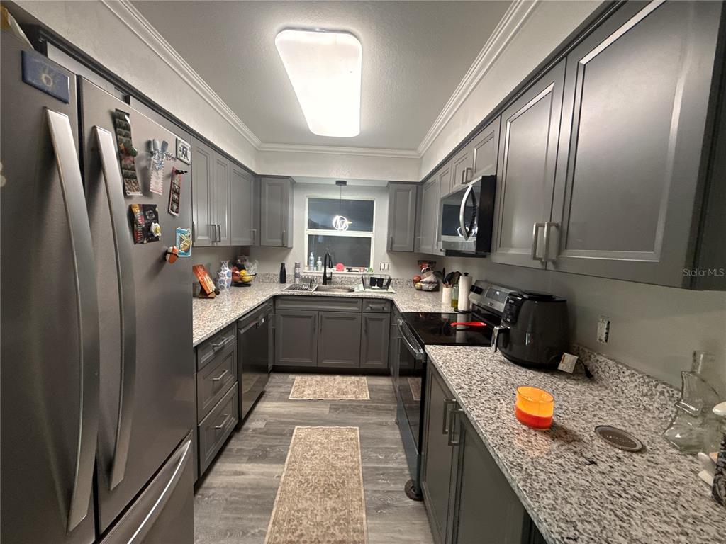 903 North Harbor Terrace Road Tavares, FL 32778 - Photo 28 of 69 a kitchen with stainless steel appliances granite countertop a refrigerator a stove top oven a sink and dishwasher