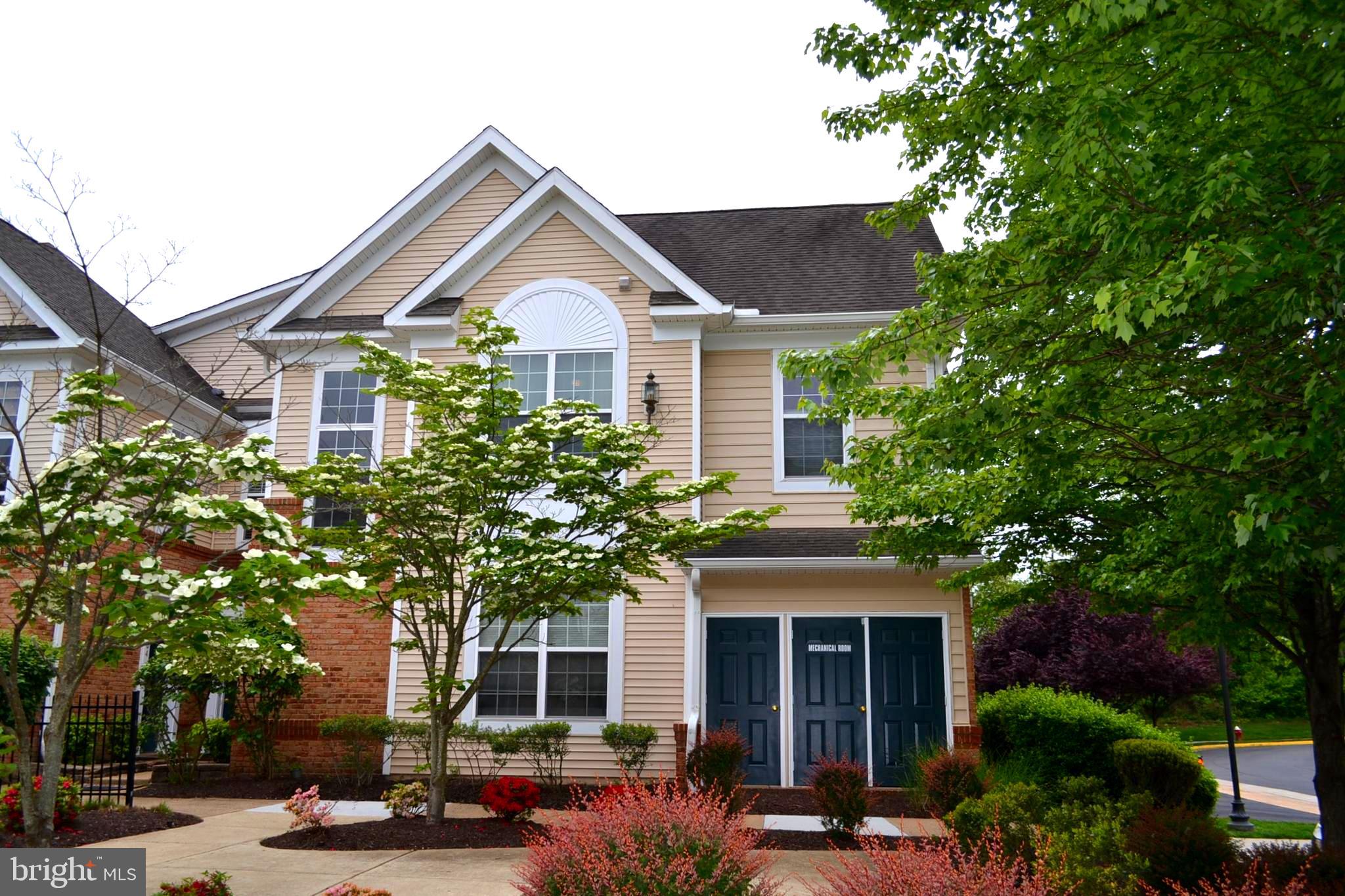 43825 Hickory Corner Terrace, Unit 101 Ashburn, VA 20147 - Photo 1 of 36 a front view of a house with a yard