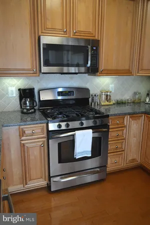 a kitchen with granite countertop a stove and a microwave