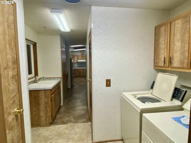 a utility room with a sink and a refrigerator