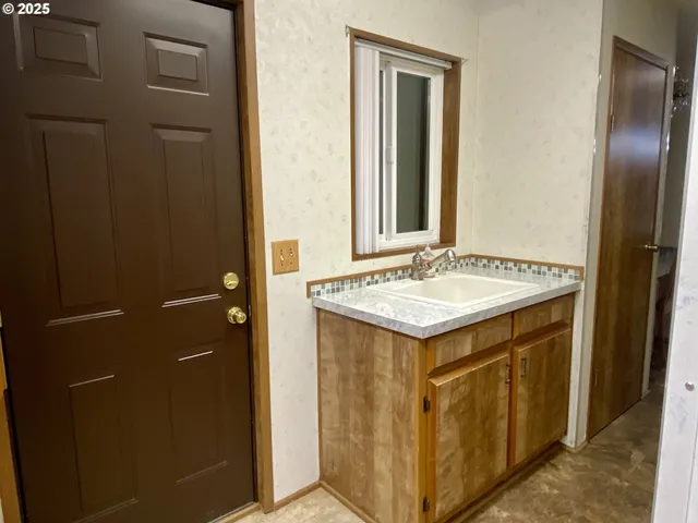 a kitchen with a sink refrigerator and cabinets