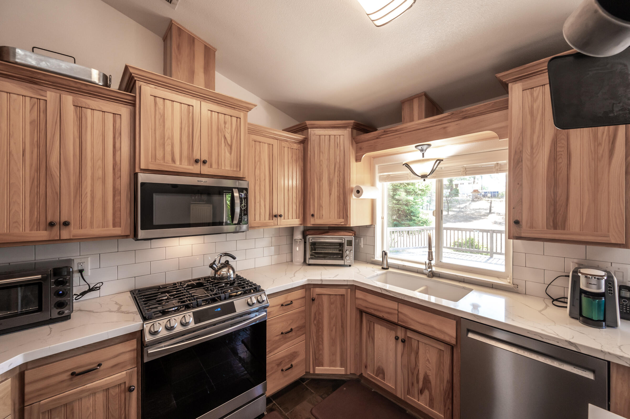 12265 Randolph Road Redding, CA 96003 - Photo 8 of 35 a kitchen with stainless steel appliances granite countertop a sink a stove a microwave and wooden cabinets