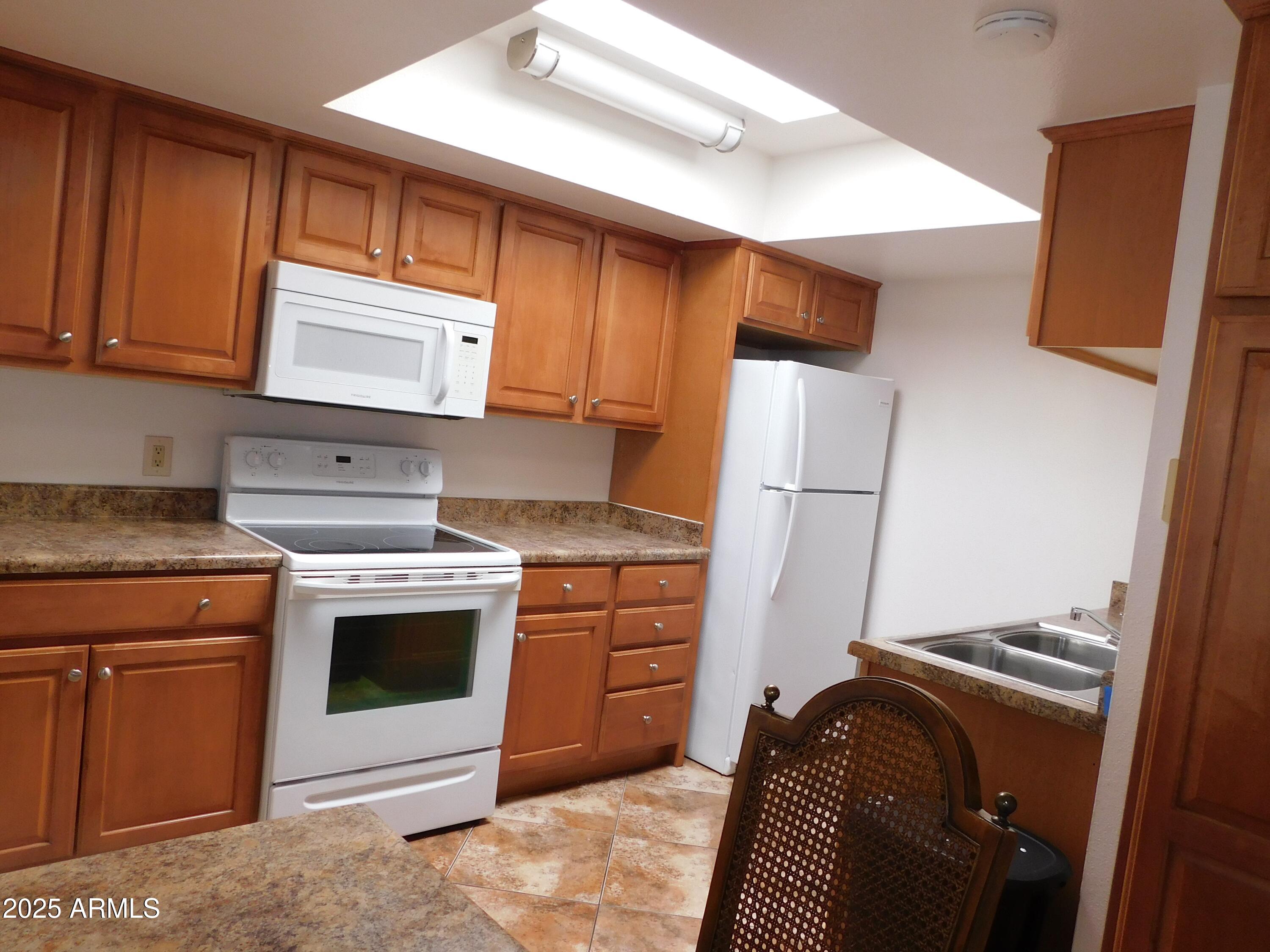 520 South Evergreen Road Tempe, AZ 85288 - Photo 8 of 24 a kitchen with sink a refrigerator and cabinets