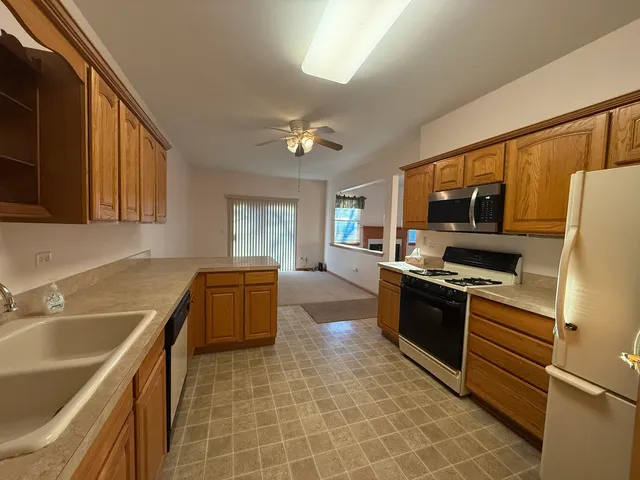 a kitchen with granite countertop a sink stove and refrigerator