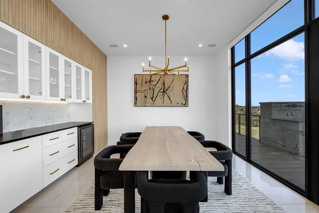 a dining room with wooden floor a chandelier a wooden table and chairs