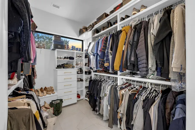a view of walk in closet with clothes