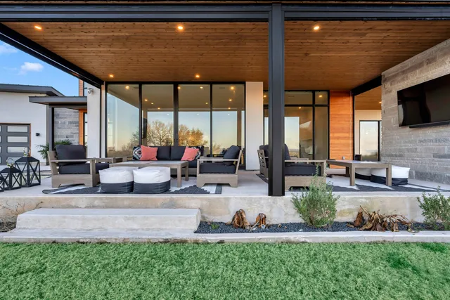 a view of a patio with table and chairs potted plants and large tree