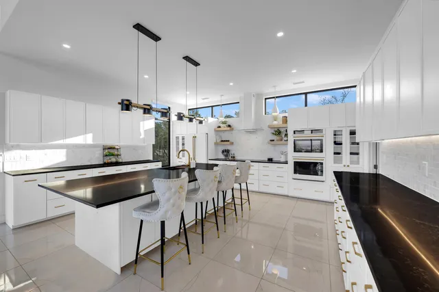 a kitchen with stainless steel appliances kitchen island granite countertop a sink and cabinets