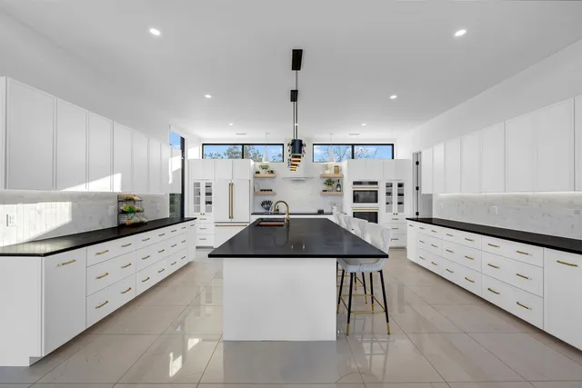 a kitchen with granite countertop a sink and white cabinets