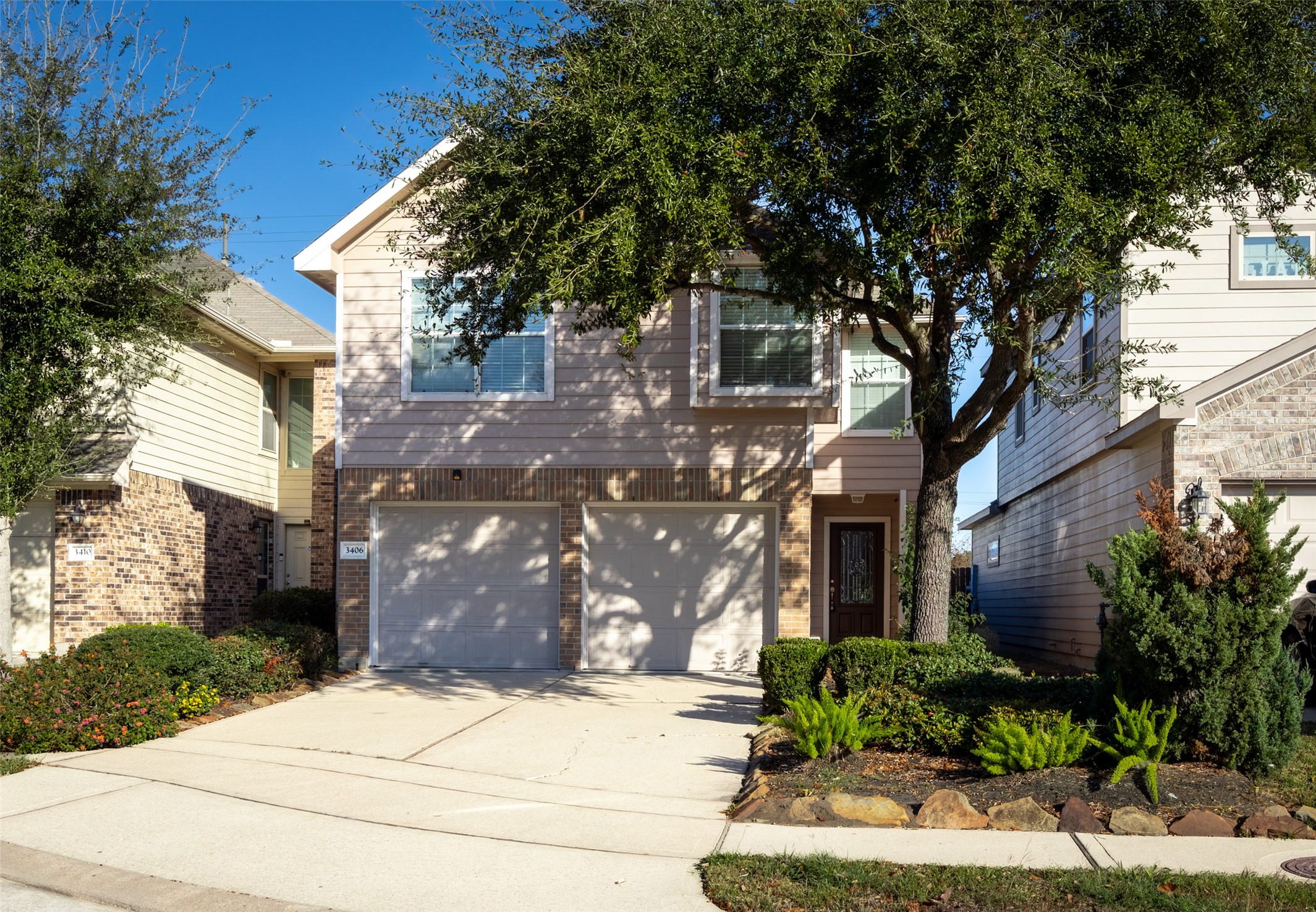 a front view of a house with a tree