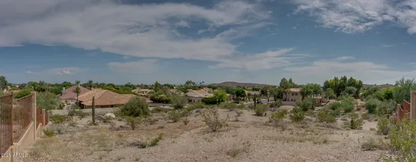 a view of a dry yard with mountains in the background