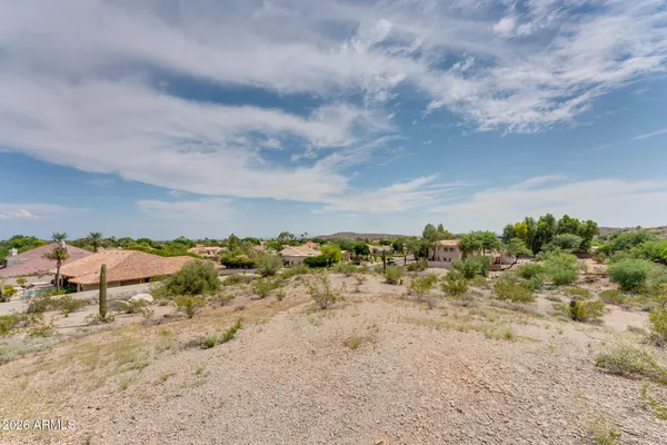 a view of a dry yard with wooden fence