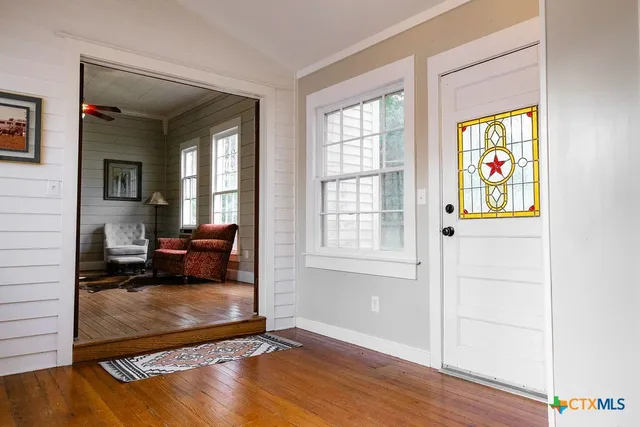 a living room with furniture a clock and a window