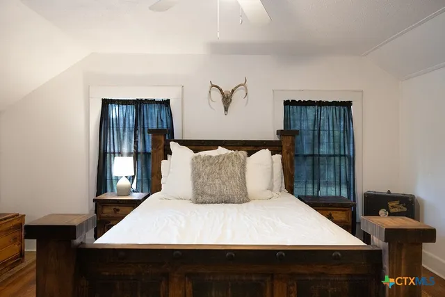 a bedroom with a bed and wooden floor