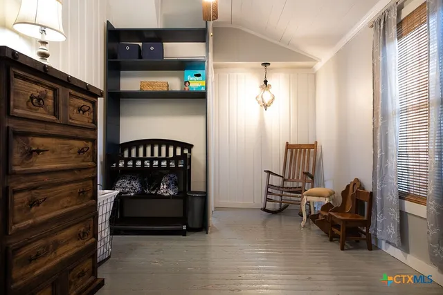 a view of room with baby crib and dresser