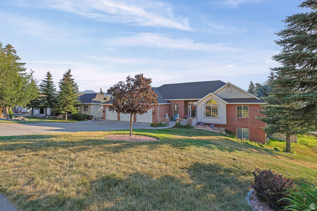 4117 North Wolf Ridge Circle Eden, UT 84310 - Photo 56 of 63 Brick and siding exterior featuring an arched window, a prominent front entrance, and an attached multi-car garage