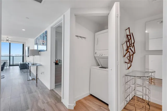 a view of a hallway with furniture and wooden floor
