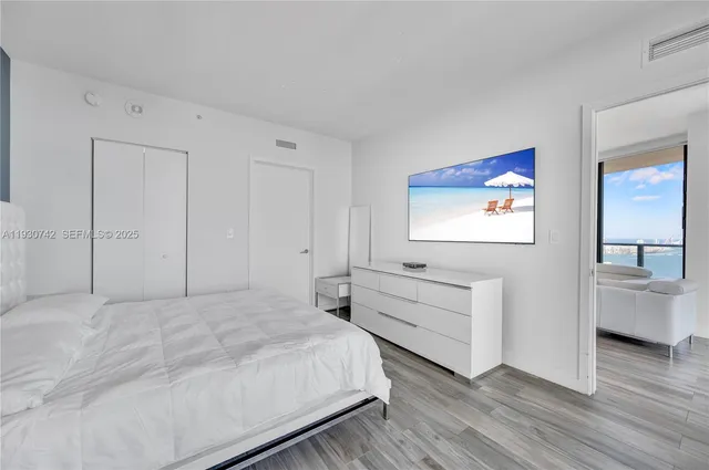 a bedroom with a bed and a flat screen tv