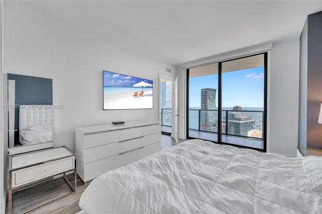 a bedroom with a bed and a large window