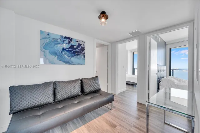 a living room with furniture and a painting on the wall