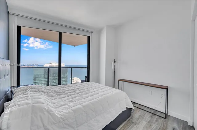 a large bed sitting in a bedroom next to a window