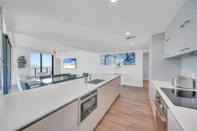 a large kitchen with stainless steel appliances a lot of counter space and a sink
