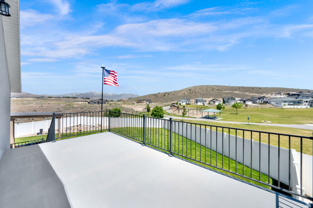 1857 Thunder Gulch Road Eagle Mountain, UT 84005 - Photo 44 of 50 Exterior deck with a black metal railing and a distant mountainous backdrop