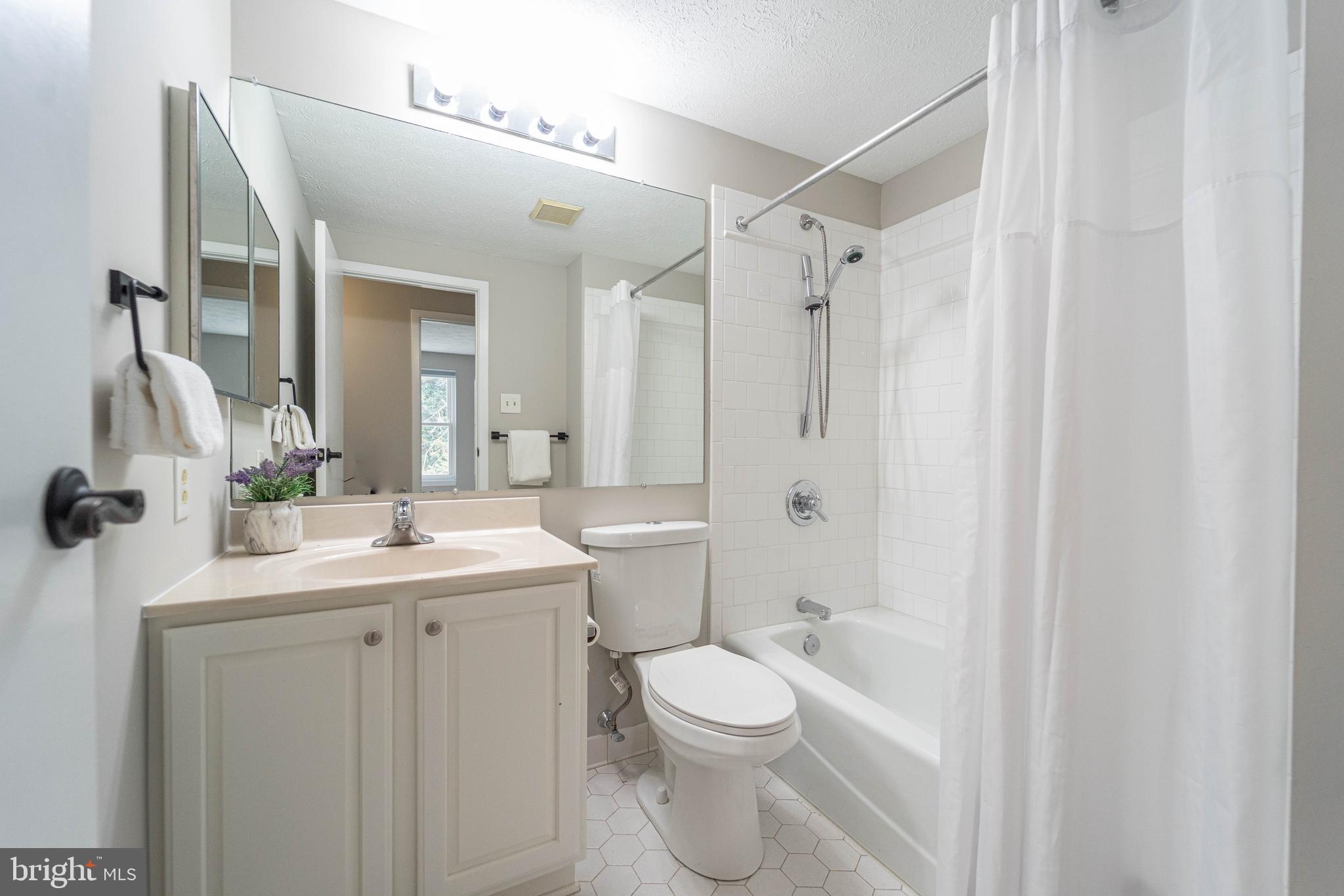6922 Pinecrest Road Catonsville, MD 21228 - Photo 23 of 36 a bathroom with a toilet a sink a mirror a vanity and shower