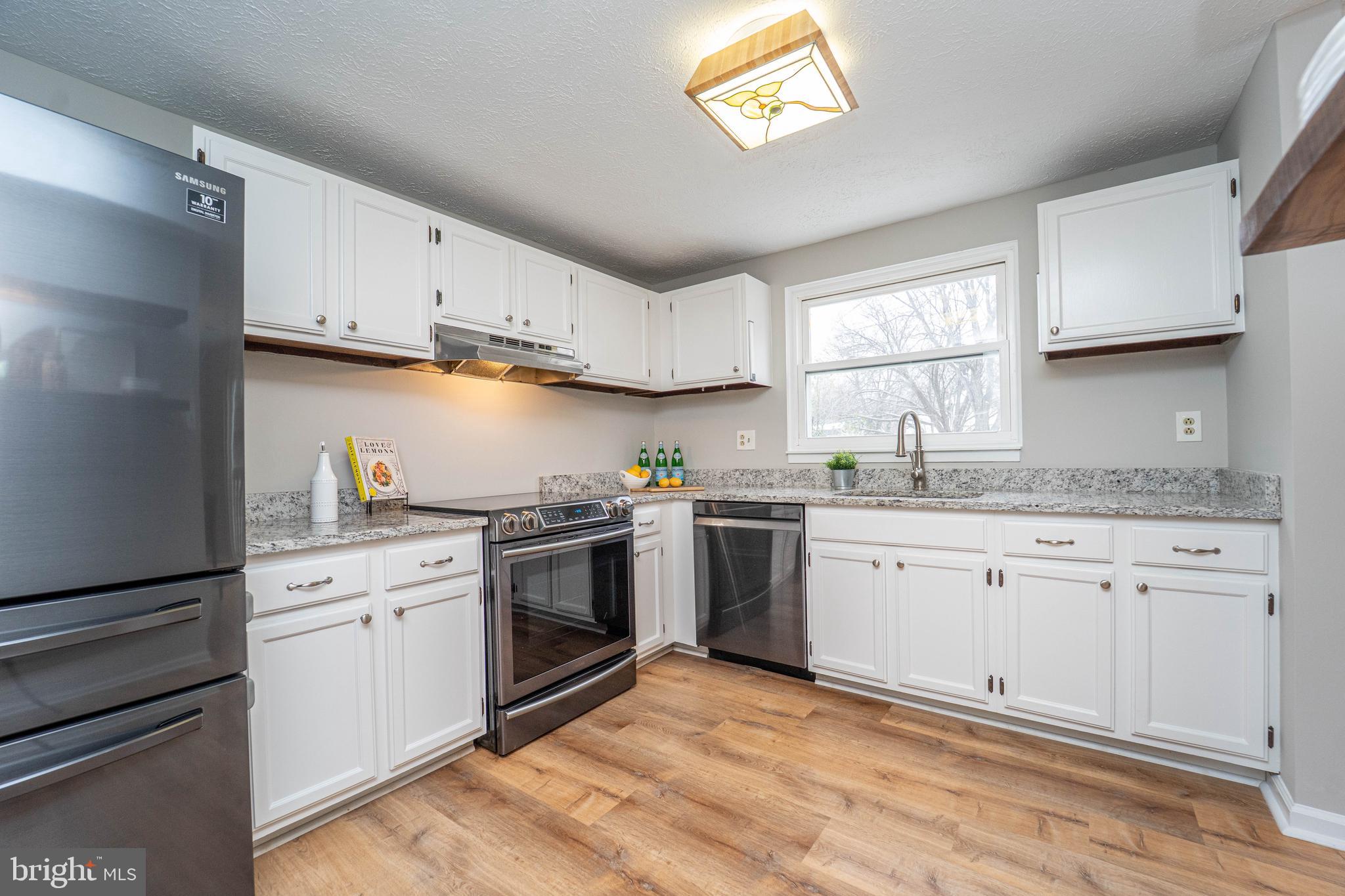 6922 Pinecrest Road Catonsville, MD 21228 - Photo 10 of 36 a kitchen with granite countertop white cabinets and white appliances