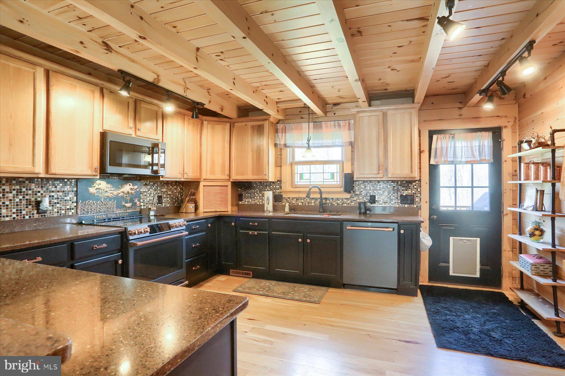 1560 Rhine Hollow Road East Waterford, PA 17021 - Photo 7 of 113 a large kitchen with stainless steel appliances granite countertop a stove granite counter tops and a window