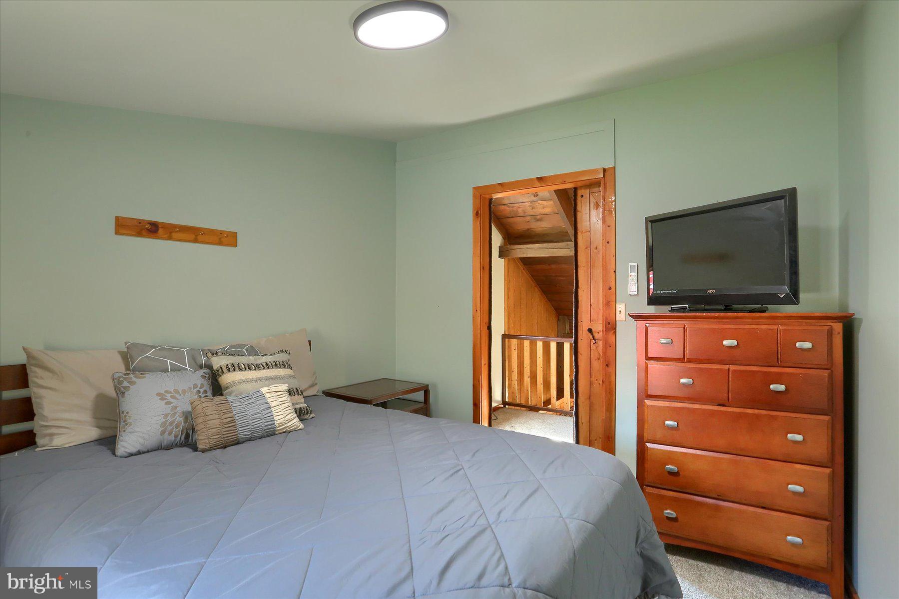 1560 Rhine Hollow Road East Waterford, PA 17021 - Photo 93 of 113 a bedroom with a bed and a flat screen tv
