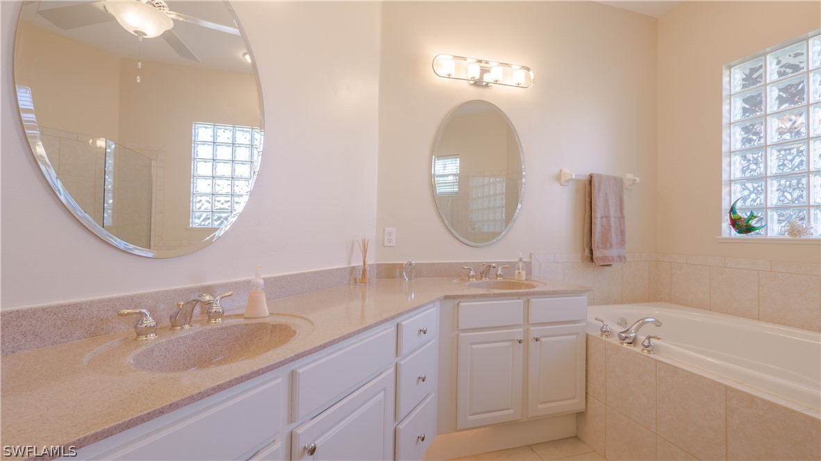 8734 Brittania Drive Fort Myers, FL 33912 - Photo 13 of 34 a bathroom with 2 sink tub and a mirror