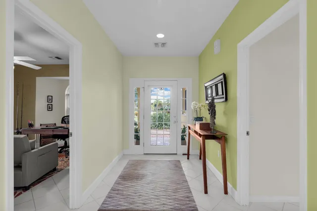 a view of a hallway to a livingroom with furniture