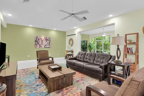 a living room with furniture kitchen view and a large window