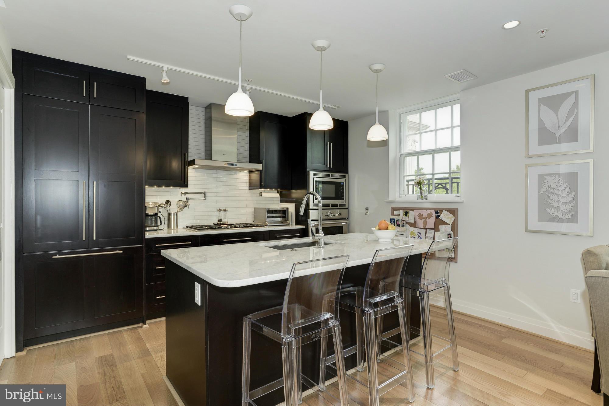 3052 R Street Northwest, Unit 304 Washington, DC 20007 - Photo 4 of 19 a kitchen with stainless steel appliances granite countertop a sink refrigerator and cabinets