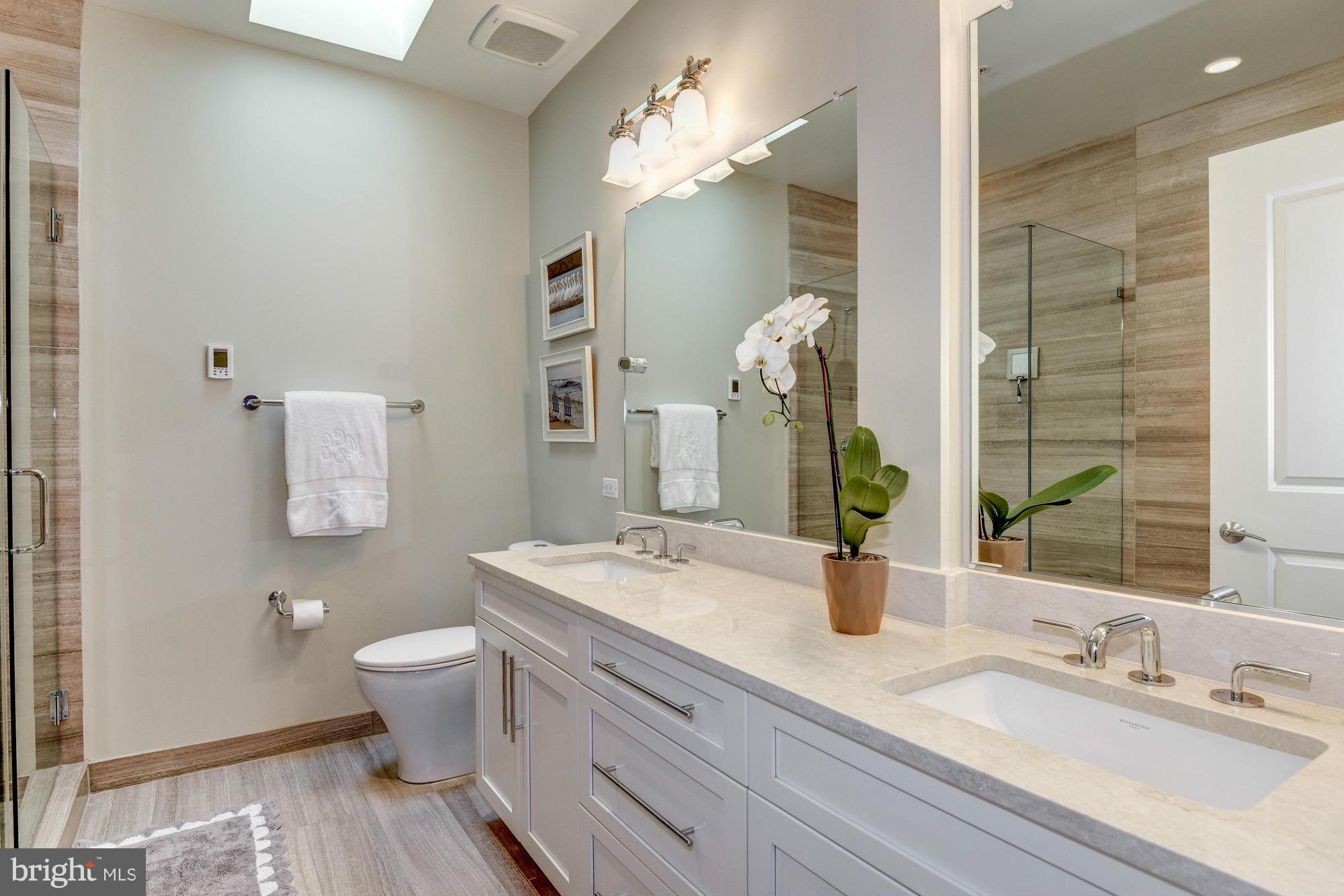 3052 R Street Northwest, Unit 304 Washington, DC 20007 - Photo 8 of 19 a bathroom with a double vanity sink mirror and toilet