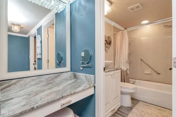 a bedroom with a large bed and a chandelier