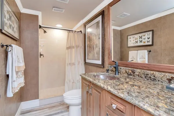 a bedroom with a large bed and a flat tv screen on dresser