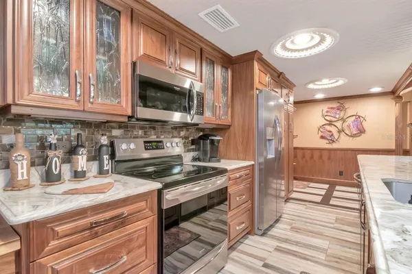 a kitchen with stainless steel appliances granite countertop a sink and a stove
